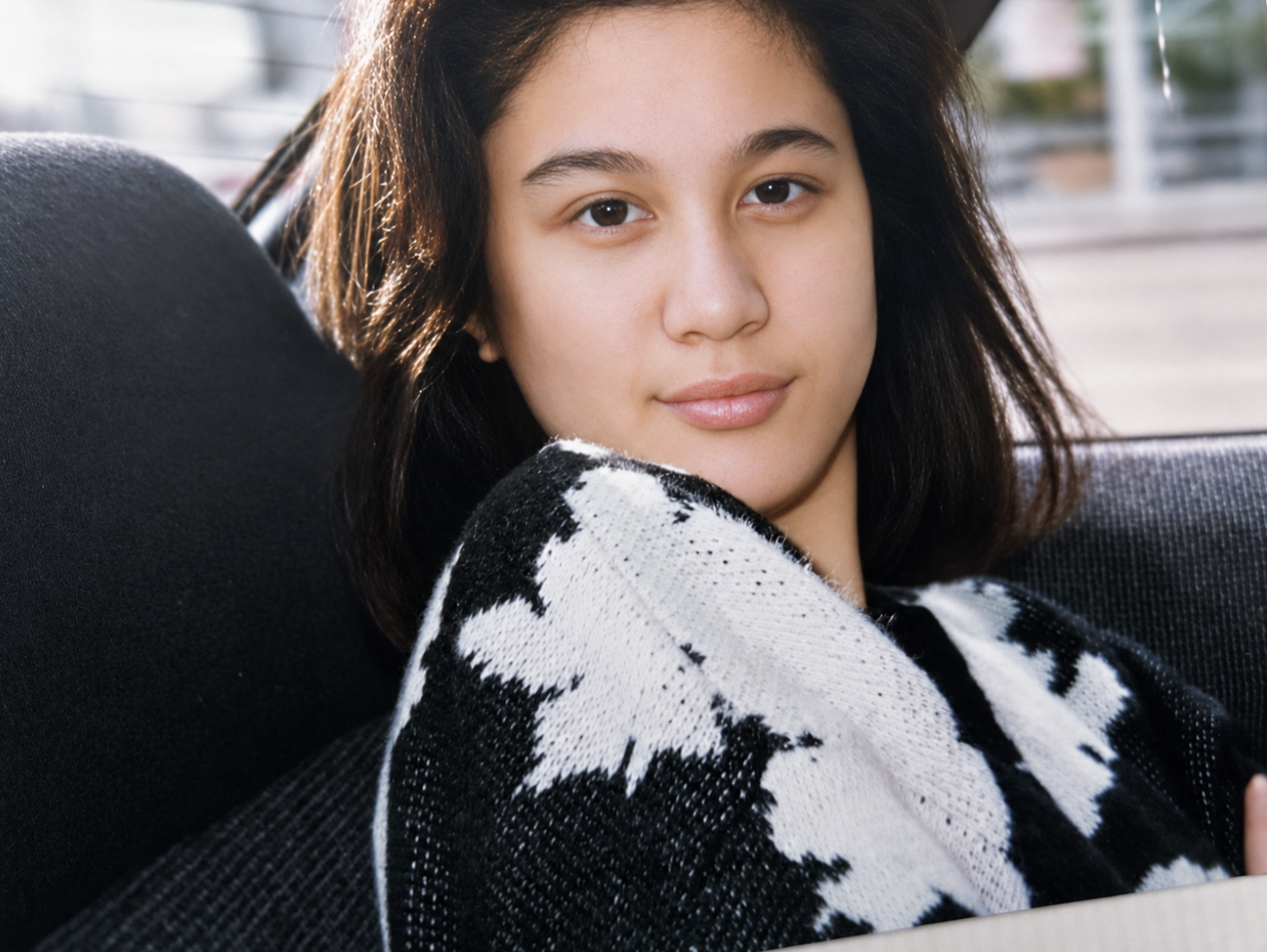 A young girl resting on a couch, looking toward the camera